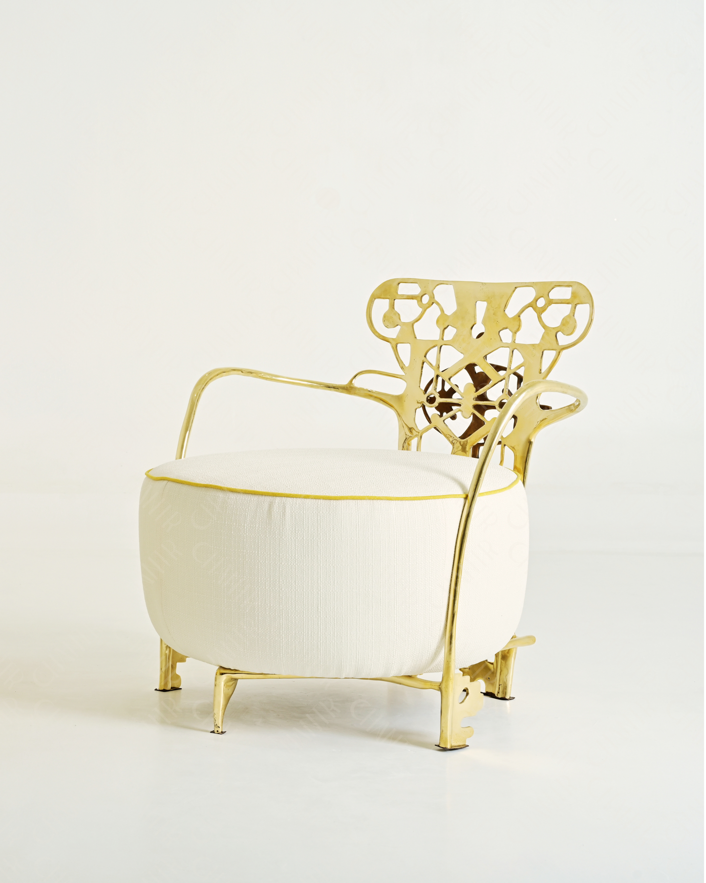Gold lounge chair with white cushion with intricate backrest design on a light gray background. Luxury handmade furniture