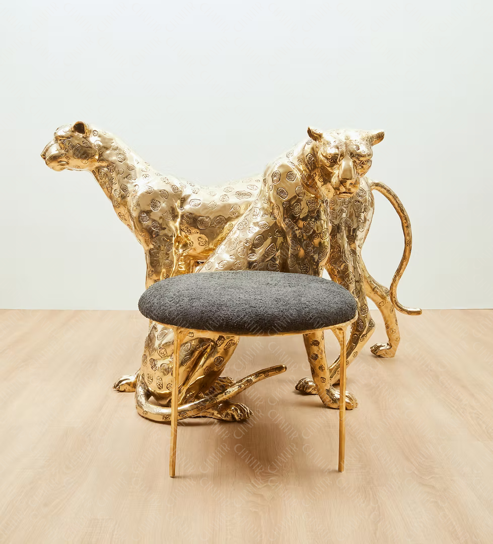 Gold brass luxury handmade furniture panther chair with gray cushion, perfect for modern luxury decor, on a wooden surface.
