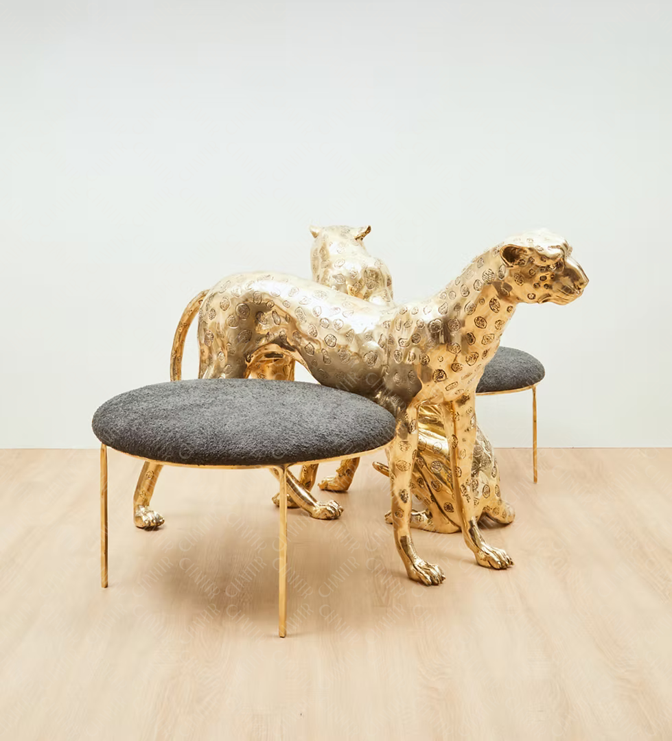 Gold brass luxury handmade furniture panther-shaped chair with gray cushion, ideal for modern luxury decor, on a beige floor.