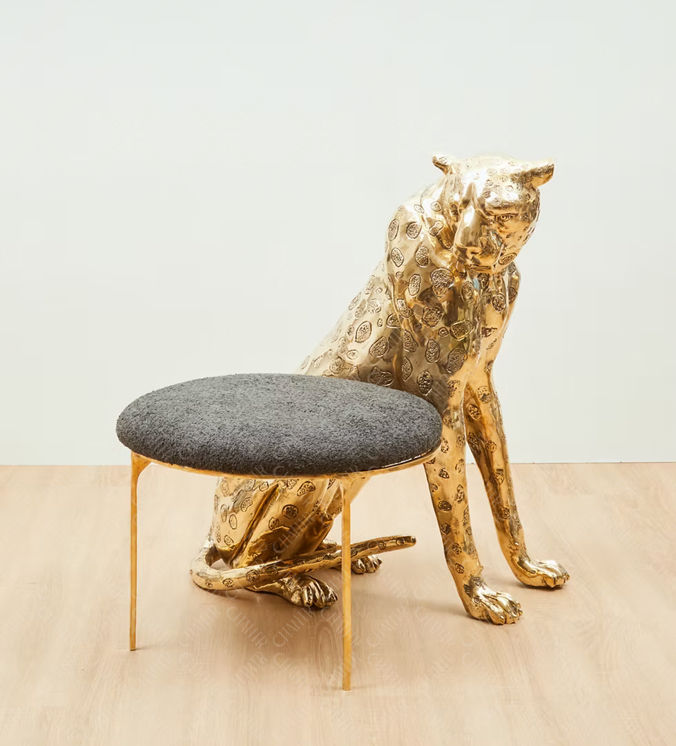 Gold brass luxury handmade furniture panther-shaped chair with gray cushion, ideal for modern luxury decor, on a beige floor.