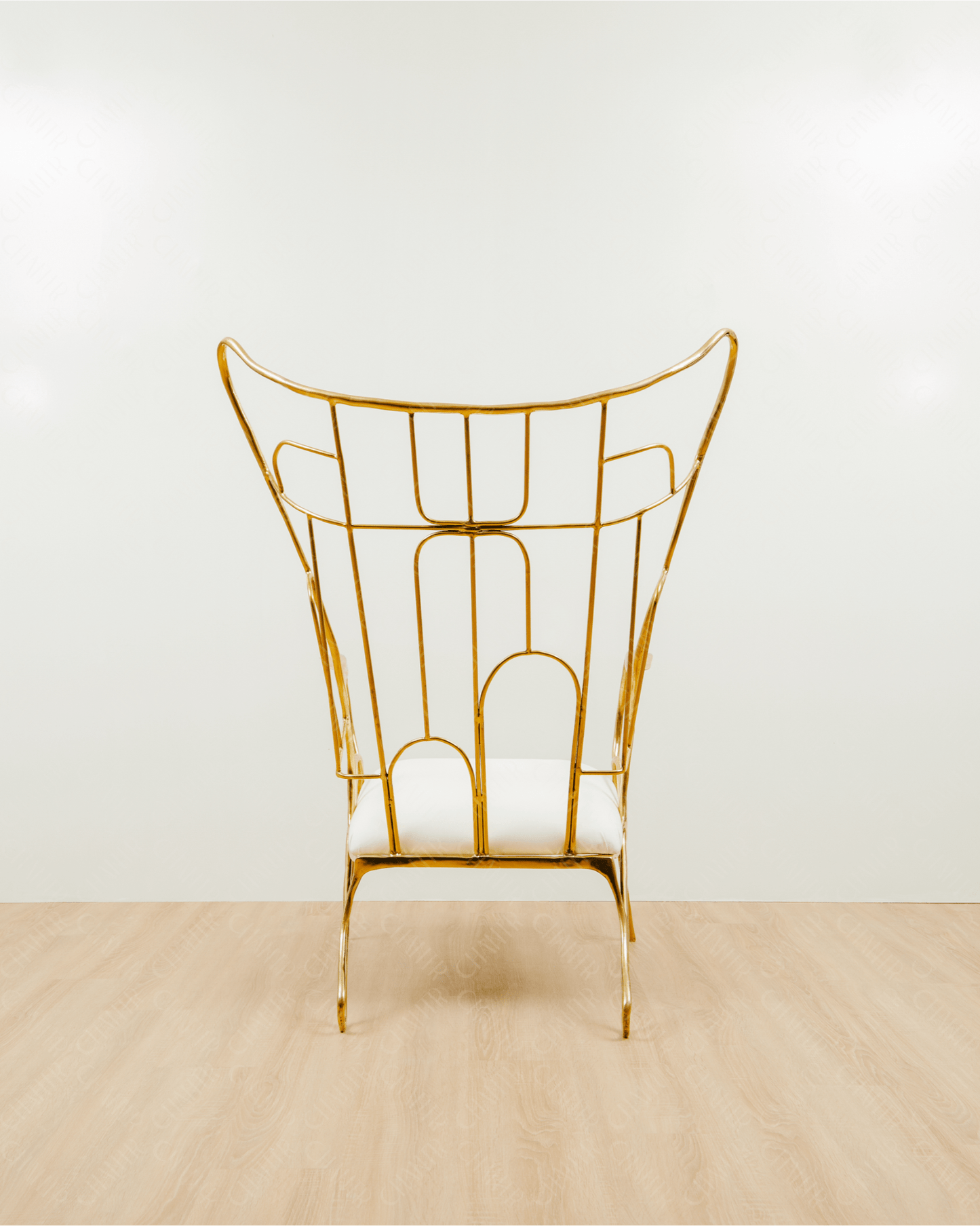 Gold brass luxury handmade furniture chair with white cushion on a light wooden floor, paired with a gold brass side table topped with a white vase, perfect for modern luxury decor. back