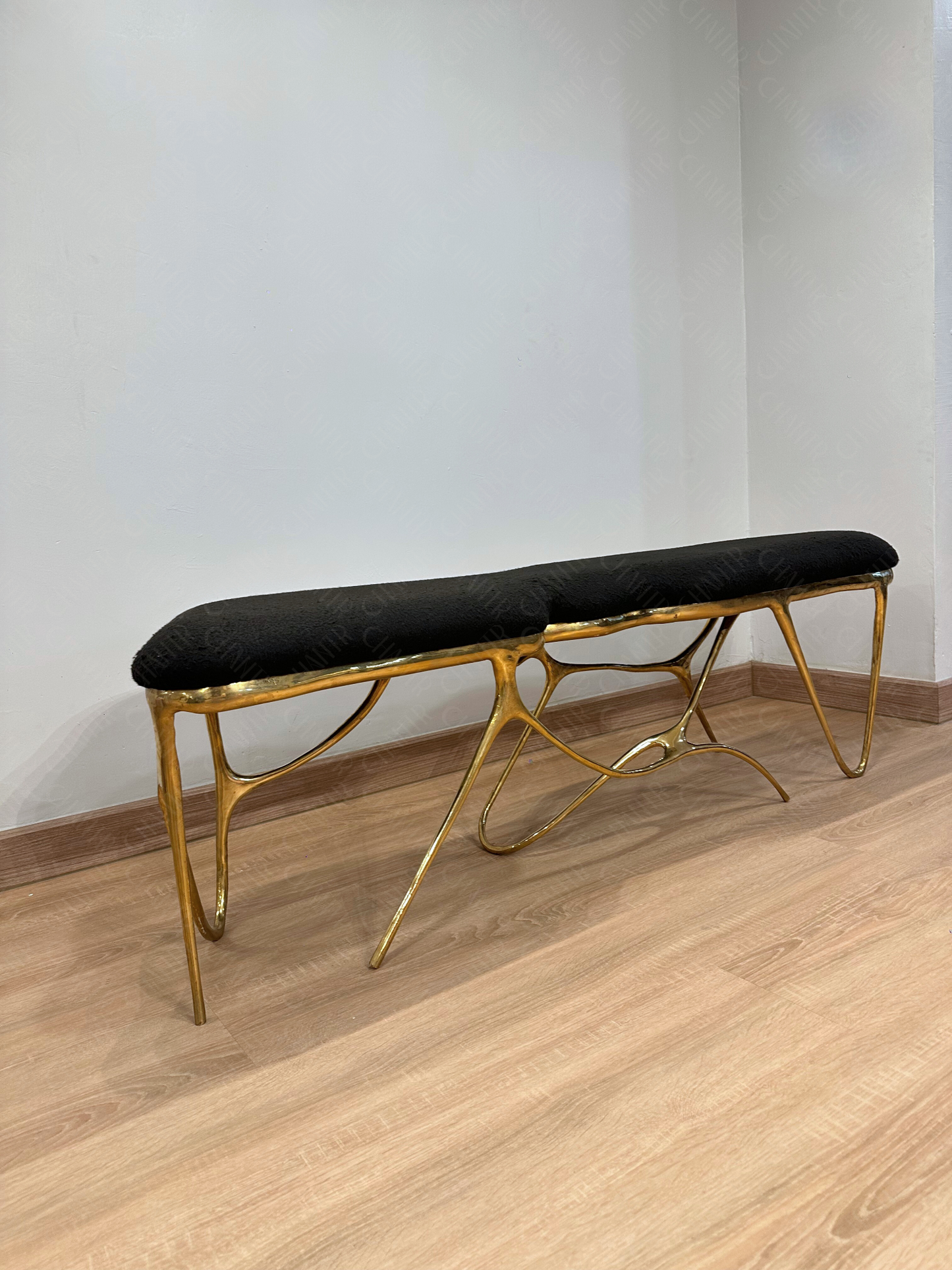 Gold brass luxury handmade furniture bench with black cushion with modern design, ideal for modern luxury decor, on a white background.