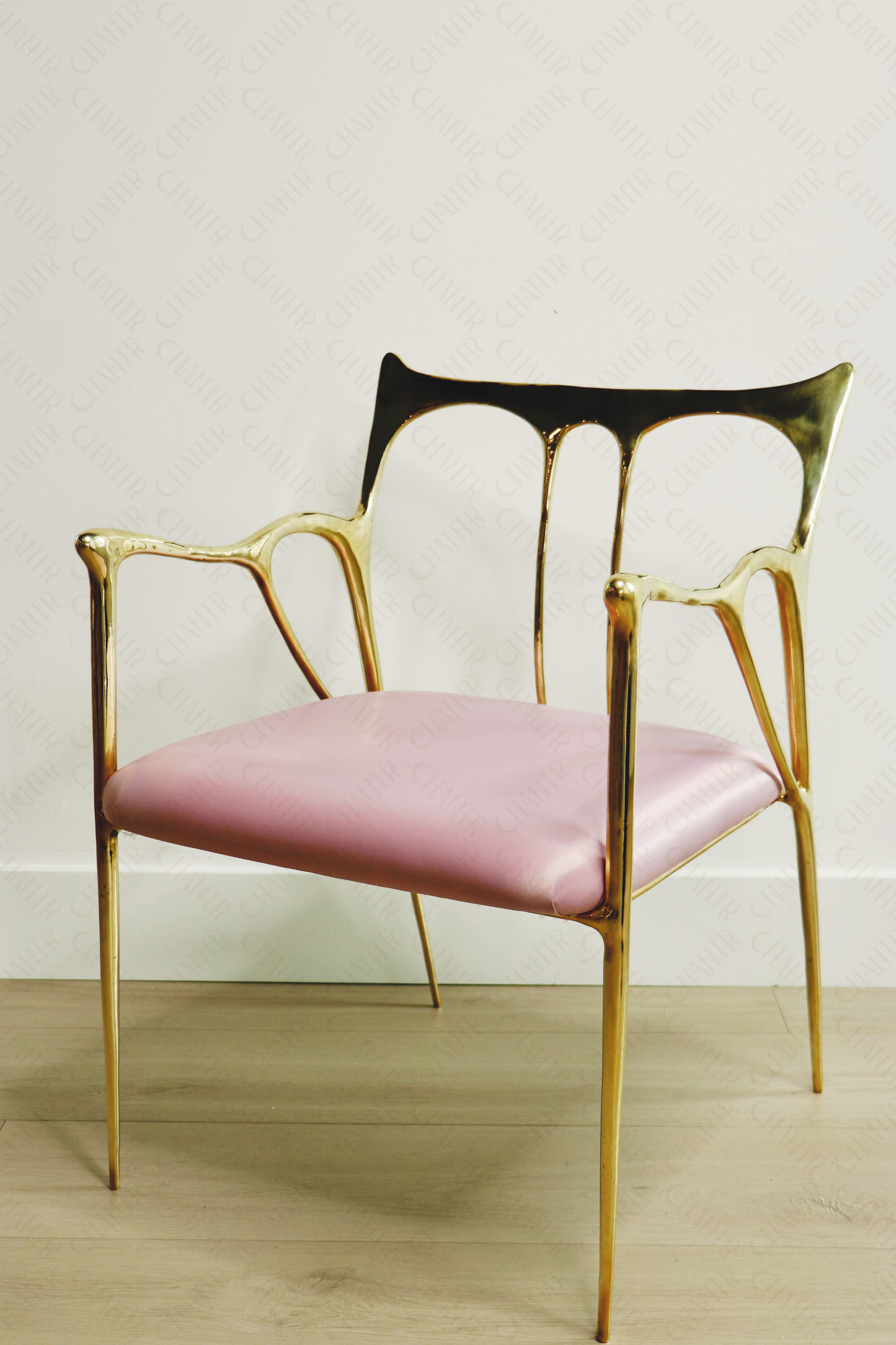 Gold brass luxury handmade furniture chair with pink cushion, ideal for modern luxury decor, on a wooden floor.