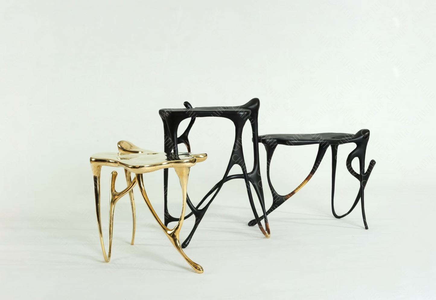 Three luxury handmade furniture stools, one gold brass and two black, designed for modern luxury decor, on a white background.