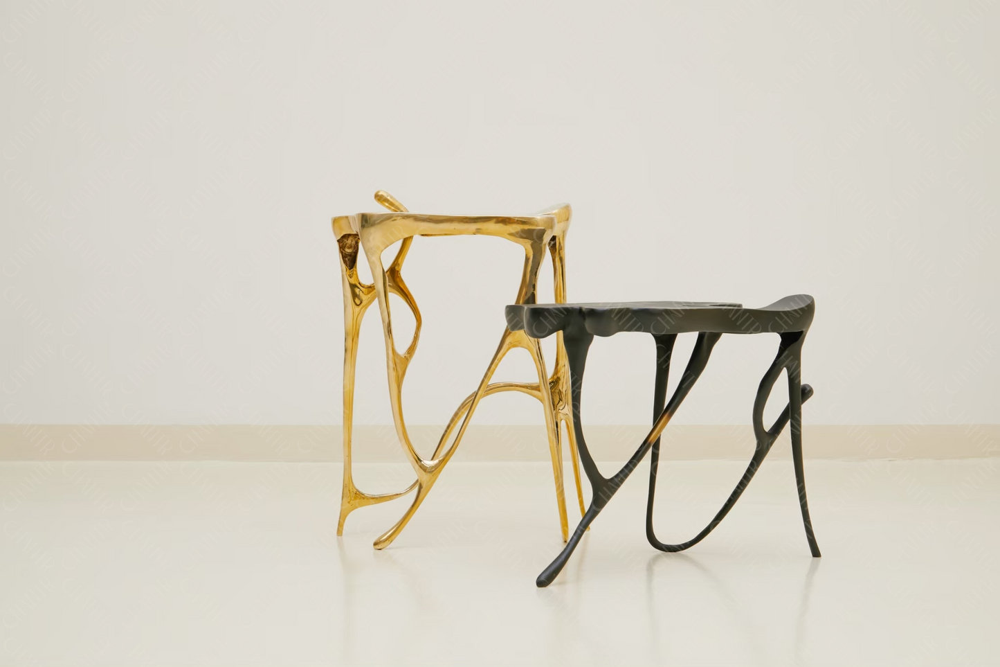 Two luxury handmade furniture stools, one gold brass and one black, designed for modern luxury decor, on a white background.