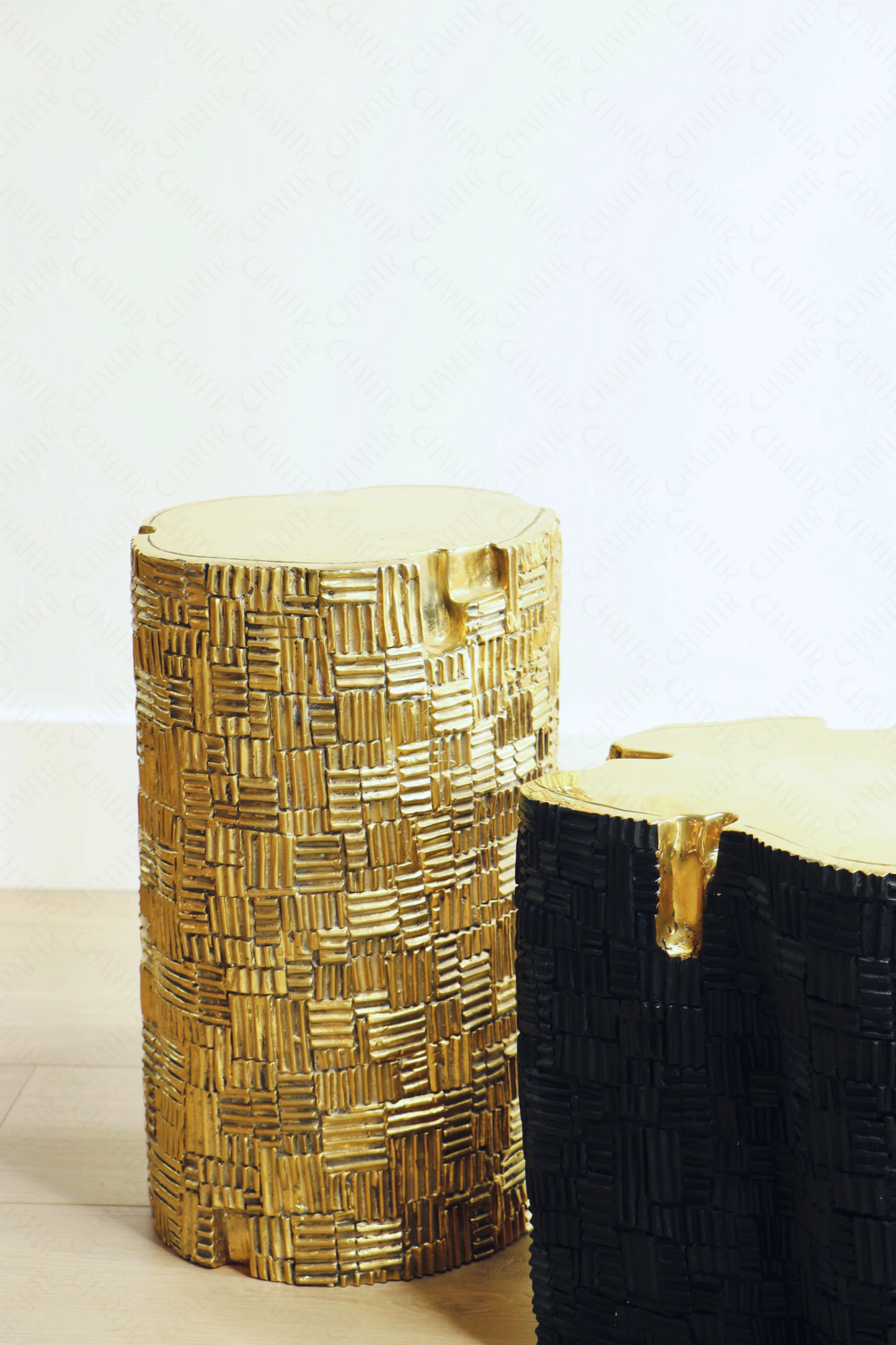Two decorative luxury handmade furniture stools, one black and one gold brass, with woven patterns, ideal for modern luxury decor, on a light background.