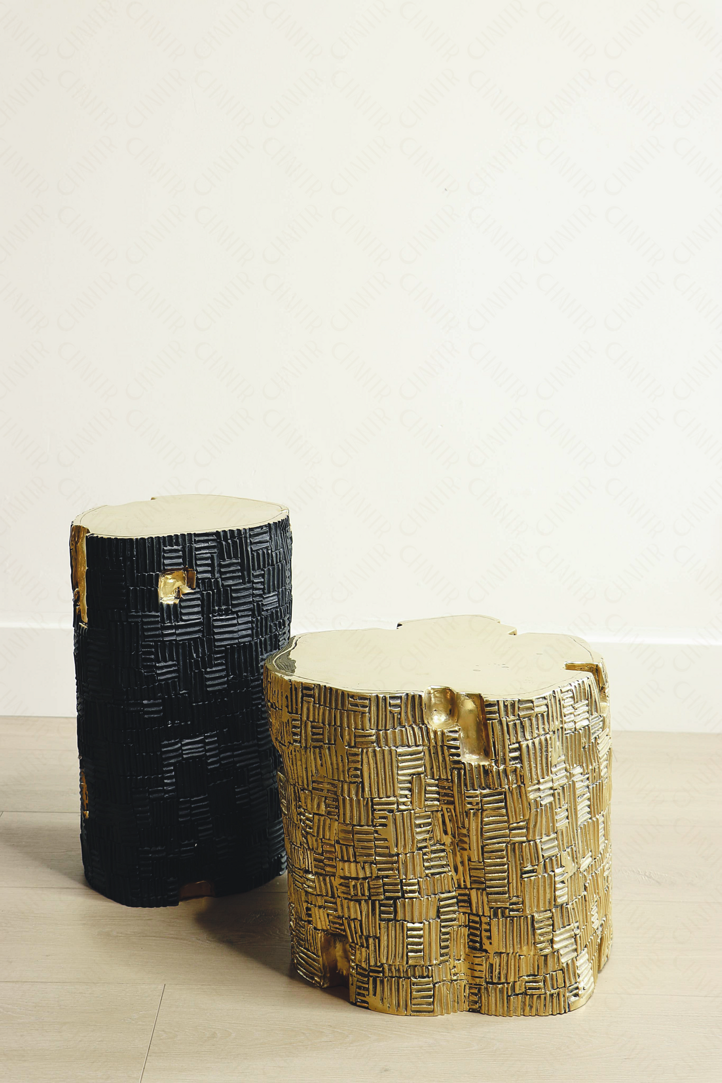 Two decorative luxury handmade furniture stools, one black (taller) and one gold brass (shorter), with woven patterns, ideal for modern luxury decor, on a light background.
