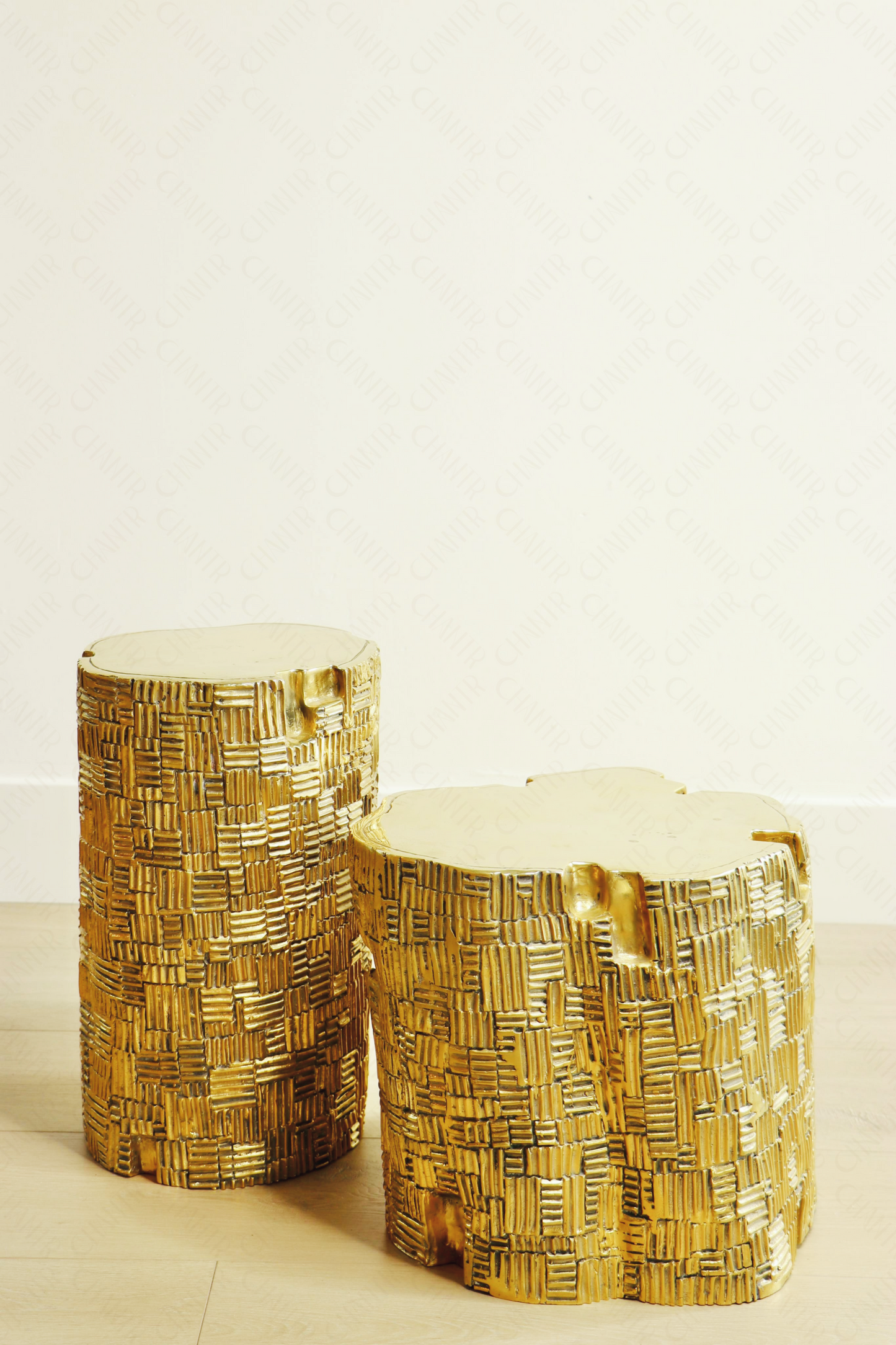 Two gold decorative luxury handmade furniture stools, one tall, one short, with woven patterns, ideal for modern luxury decor, on a light background.