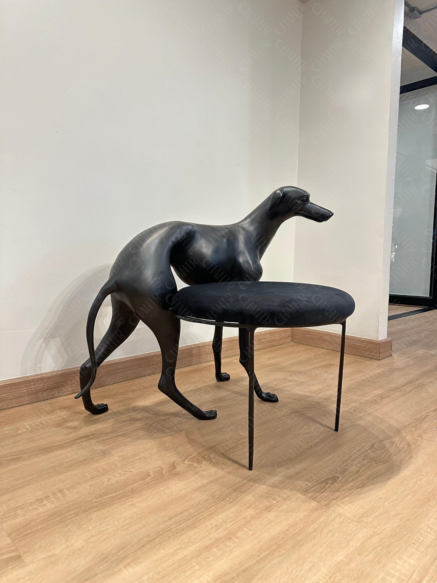 Black dog-shaped chair with a black cushion on a wooden floor. Luxury Handmade Furniture