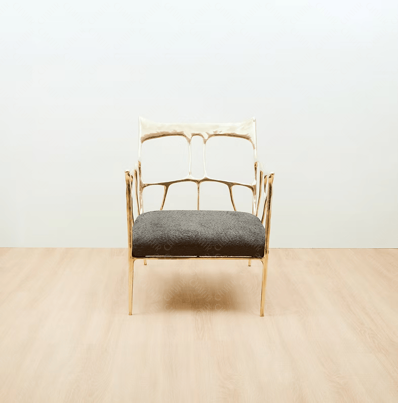 Gold brass luxury handmade furniture armchair with textured gray cushion, ideal for modern luxury decor, on a beige floor with white wall background. straight angle