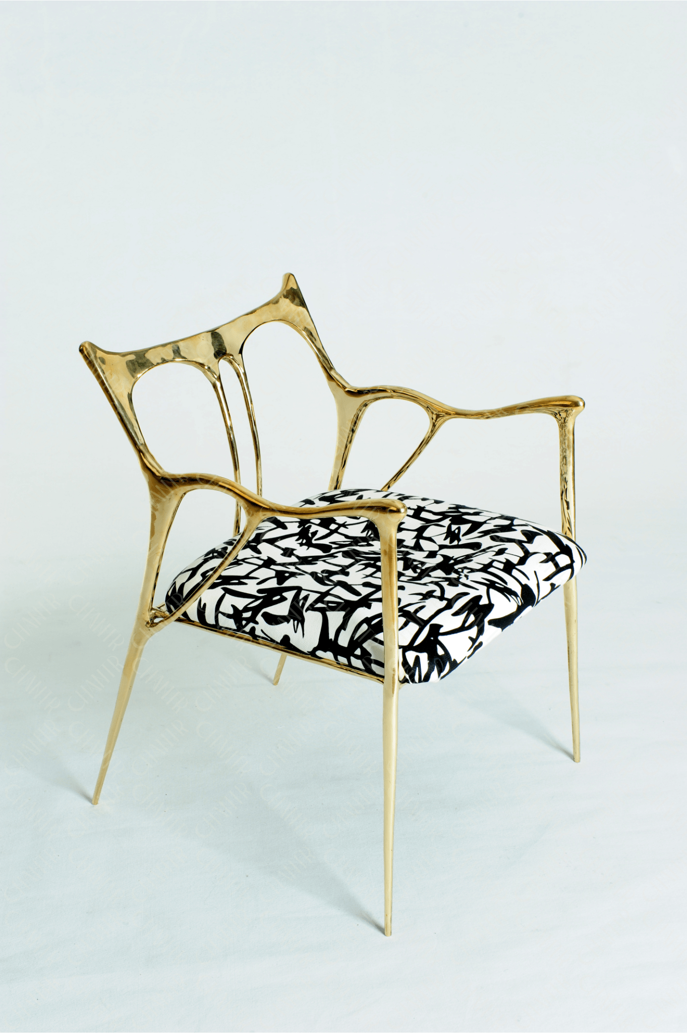 Gold brass luxury handmade furniture chair with patterned cushion, ideal for modern luxury decor, on a wooden floor.