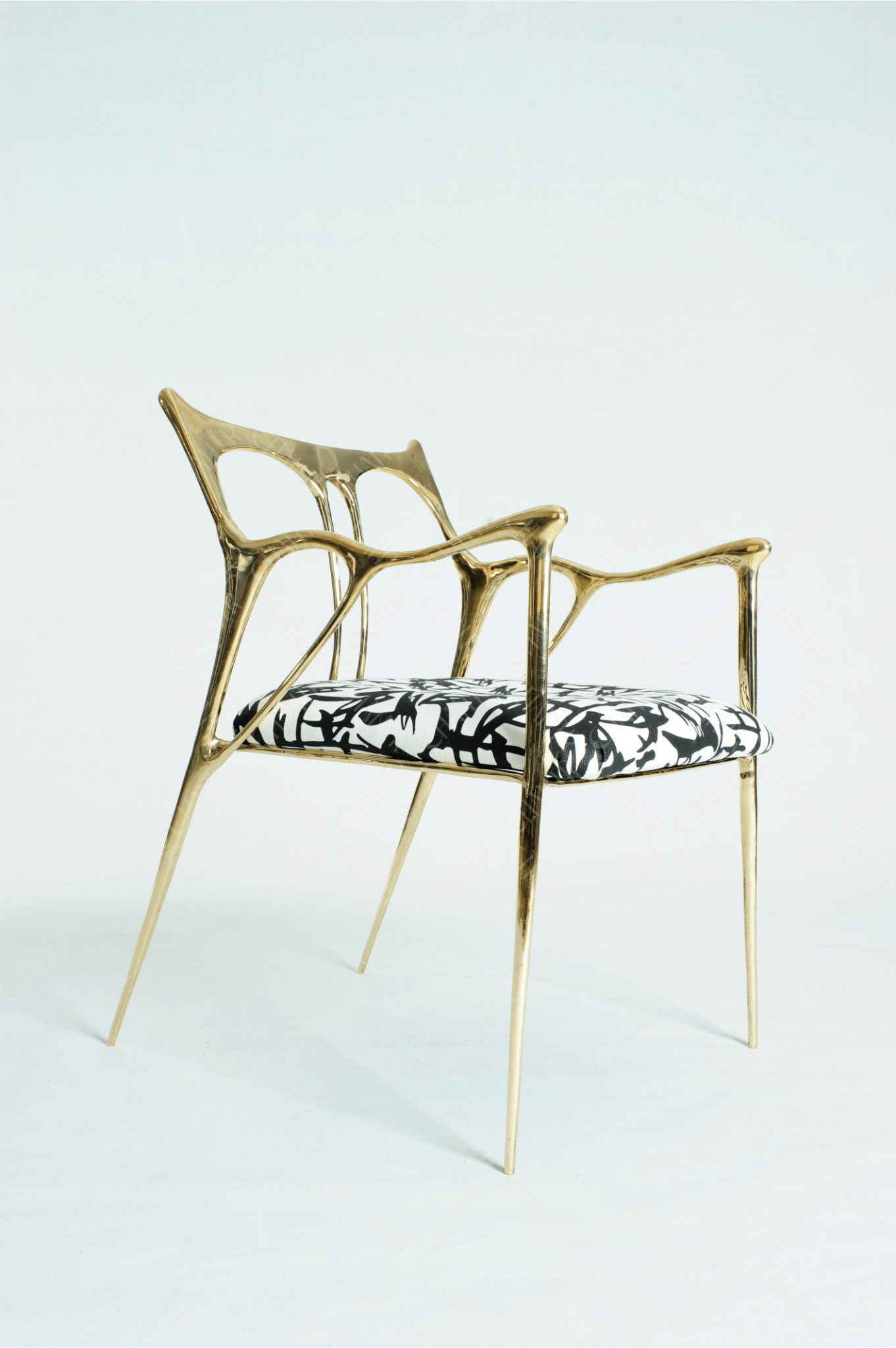 Gold brass luxury handmade furniture chair with patterned cushion, ideal for modern luxury decor, on a wooden floor.