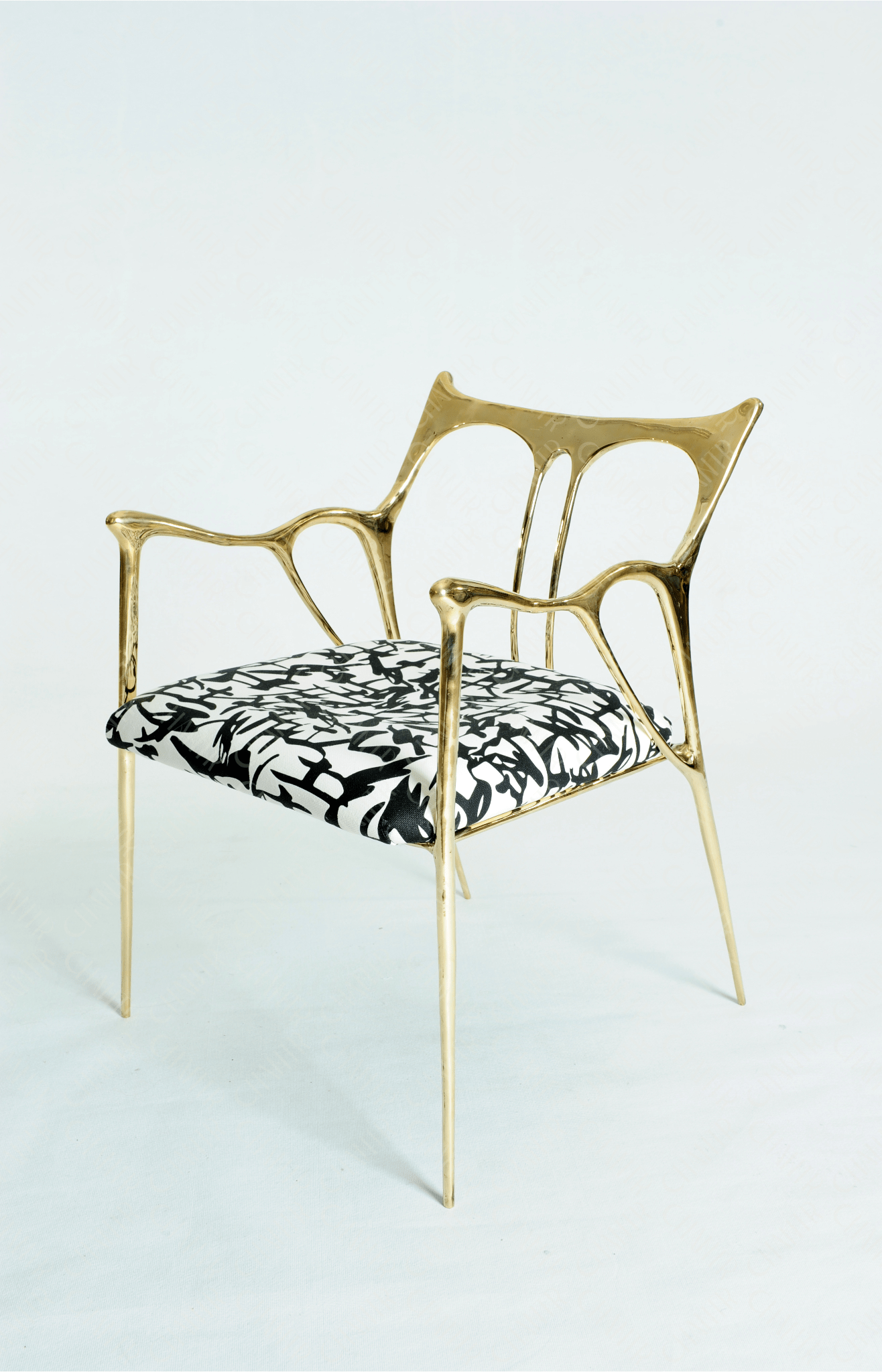 Gold brass luxury handmade furniture chair with patterned cushion, ideal for modern luxury decor, on a wooden floor.