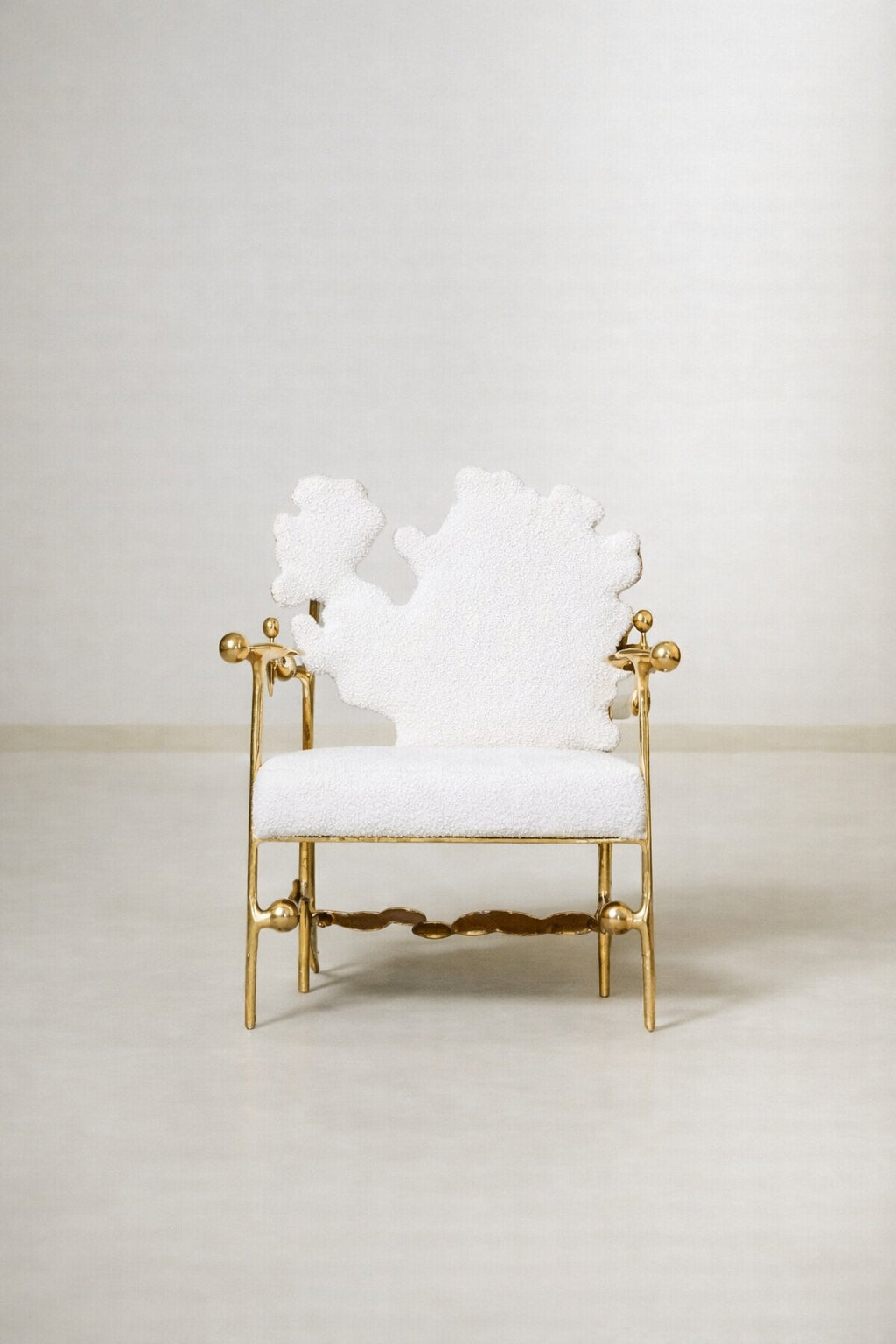 Spyoom brass lounge chair with white fabric.