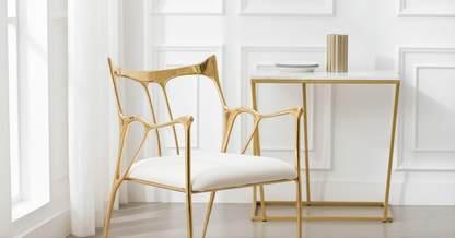 Gold brass chair and table in a bright, minimalistic room