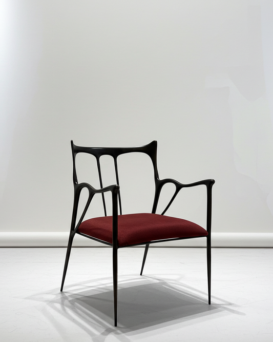 Modern brass black chair with red cushion on a white background