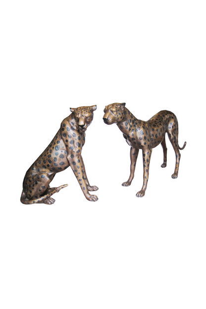 Two bronze statues of leopards on a white background