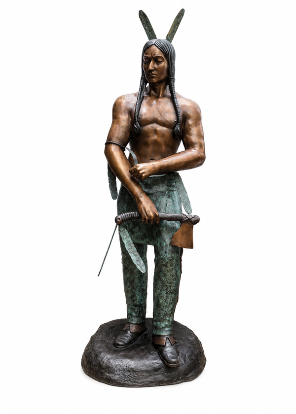 A bronze statue of a Native American man standing on a dark base, holding a sword, with long hair and feather-like headwear, isolated on a white background.