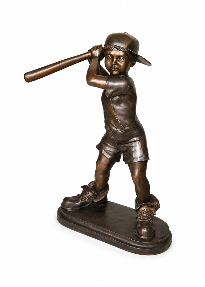 Bronze-finished sculpture of a young baseball player in a batting stance, holding a bat over his shoulder, mounted on an oval base against a plain white background.