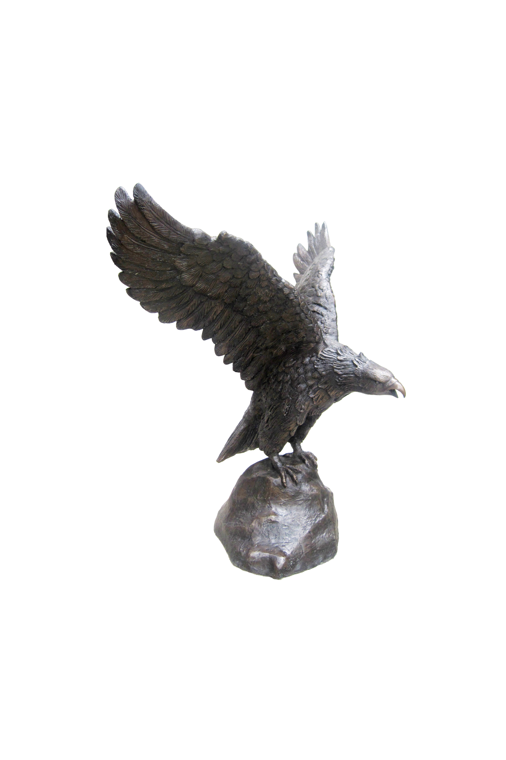 Bronze statue of an eagle perched on a rock against a white background