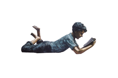 Statue of a person lying on their stomach reading a book against a white background