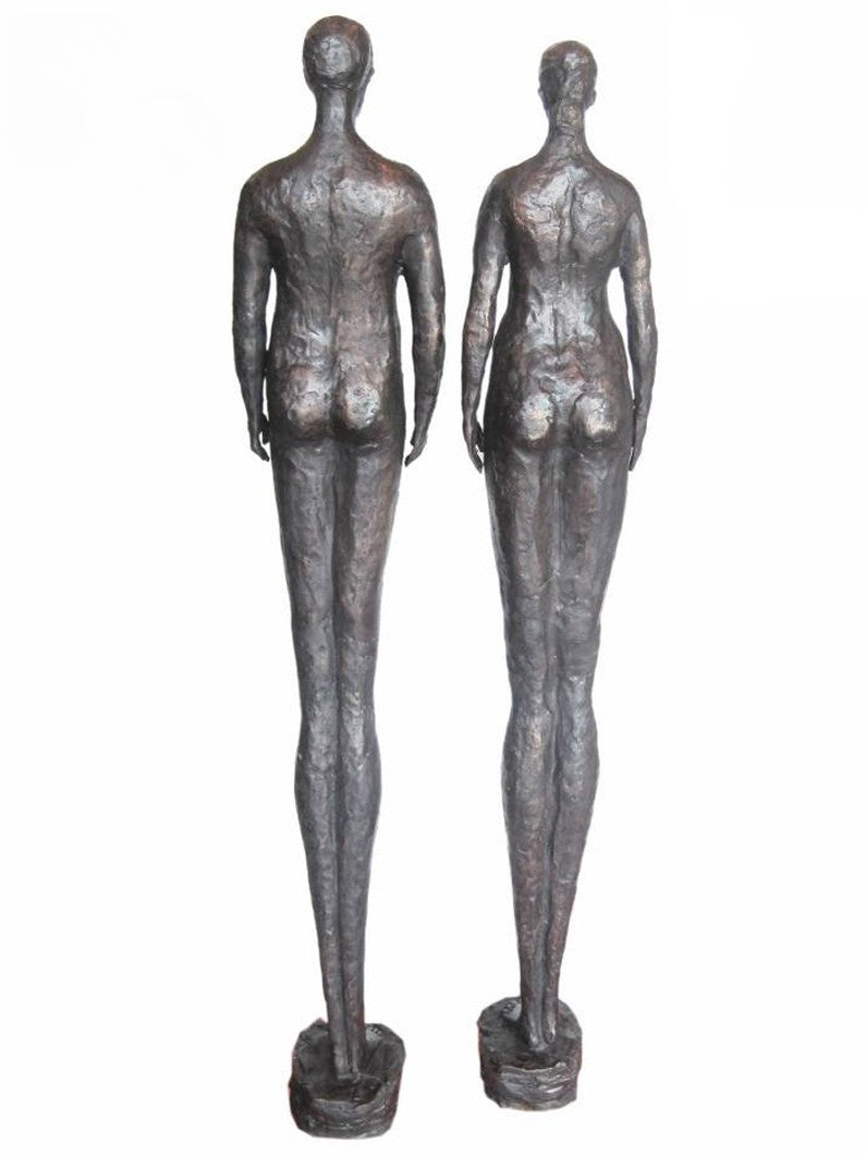 Two bronze luxury handmade furniture statues of standing figures, ideal for modern luxury decor, on a white background. - back side
