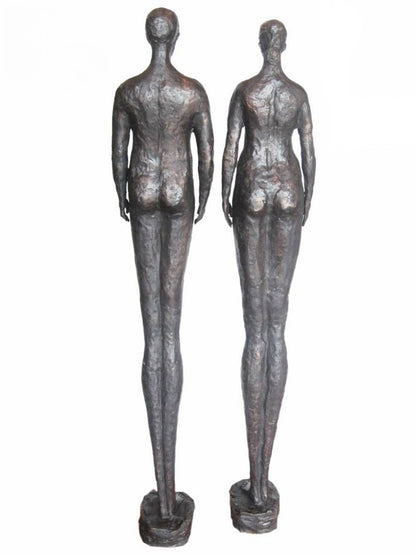 Two bronze luxury handmade furniture statues of standing figures, ideal for modern luxury decor, on a white background. - back side