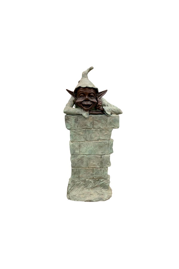 Bronze Statue of a goblin resting out on tons of bricks on a white background