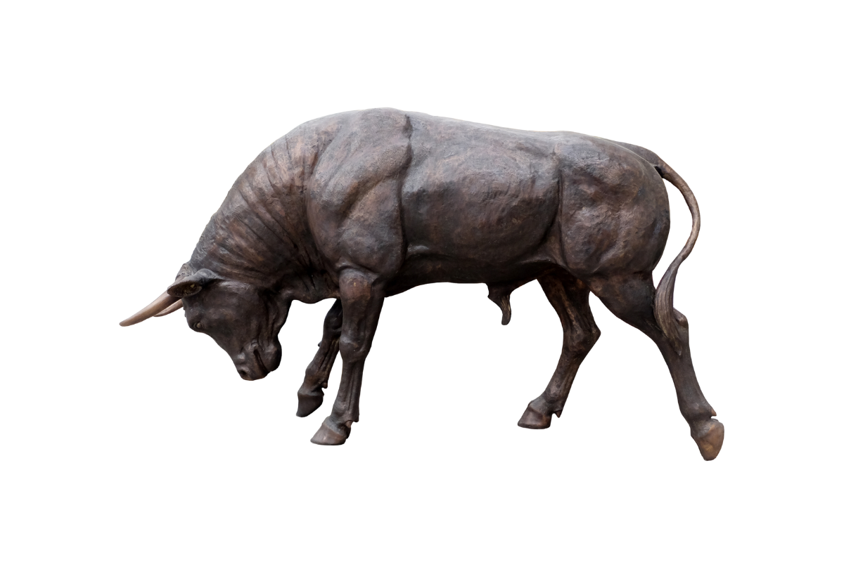 Bronze sculpture of a charging bull on a white background