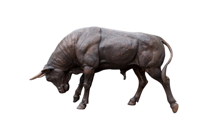 Bronze sculpture of a charging bull on a white background