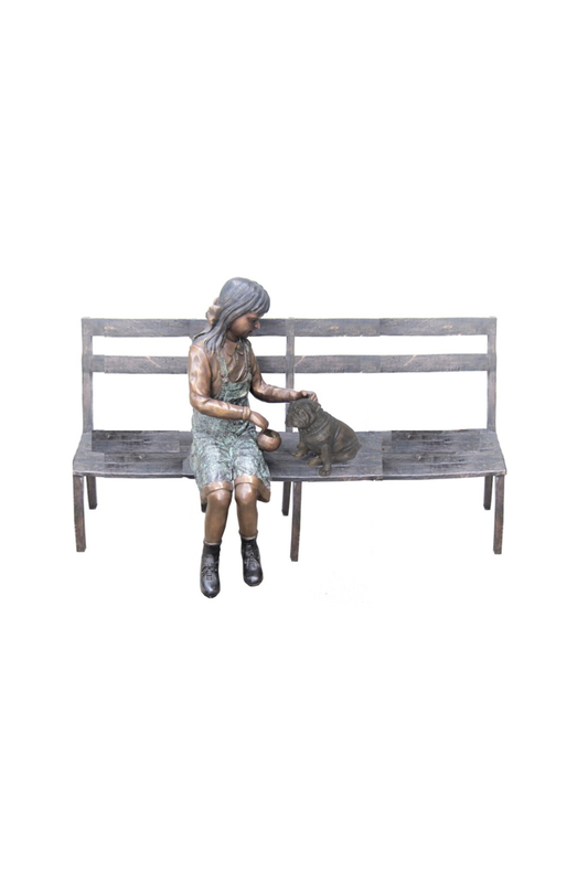 bronze Statue of a woman sitting on a bench with a dog on a white background