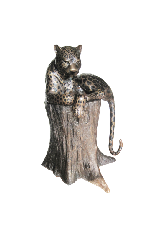 Decorative bronze figurine of a leopard on a tree stump against a white background