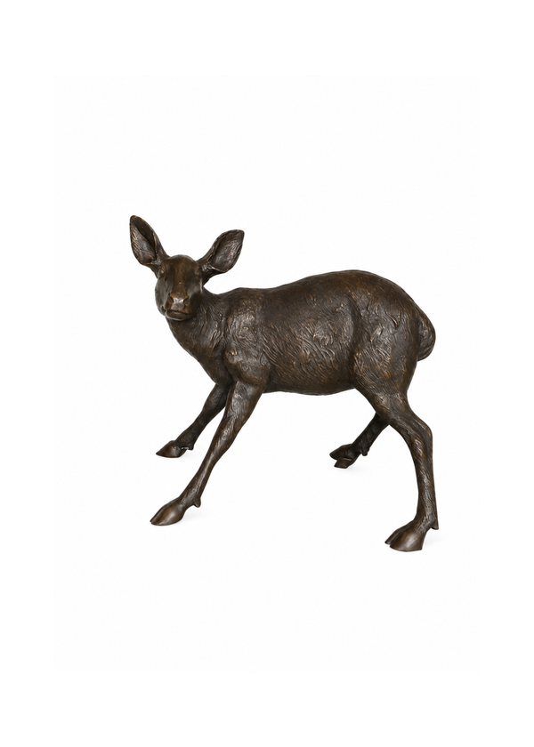 A small bronze deer figurine standing in profile, photographed on a plain white background.