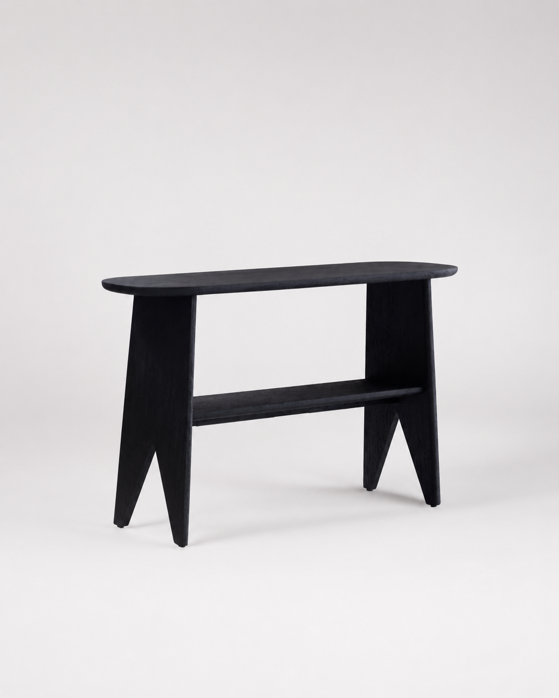 A minimalist black wooden console table with a rounded rectangular top, angled legs, and a lower shelf, photographed against a seamless light gray studio background.