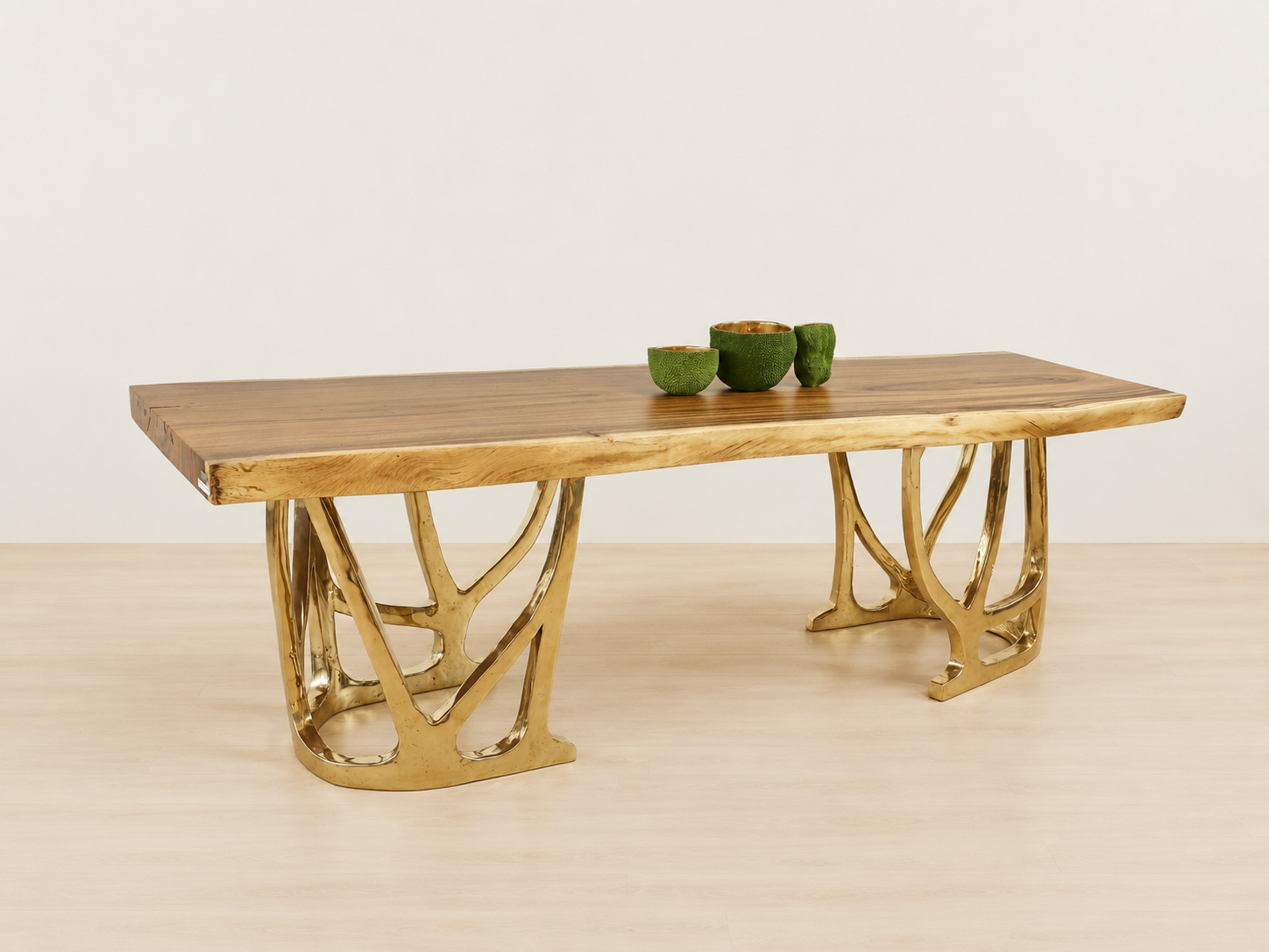 side view of a dining table with gold bronze base and wood table top.