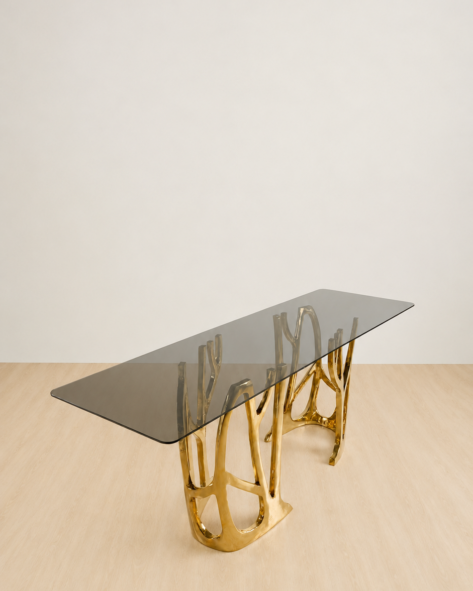 Gold brass console table with a dark glass top, shown from the side