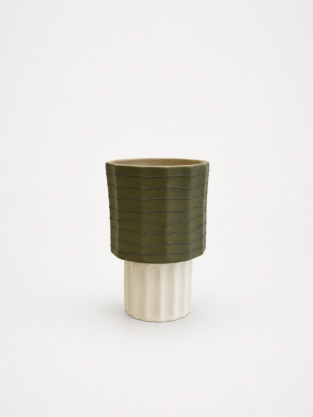 Green ceramic vase with ribbed texture on a white background