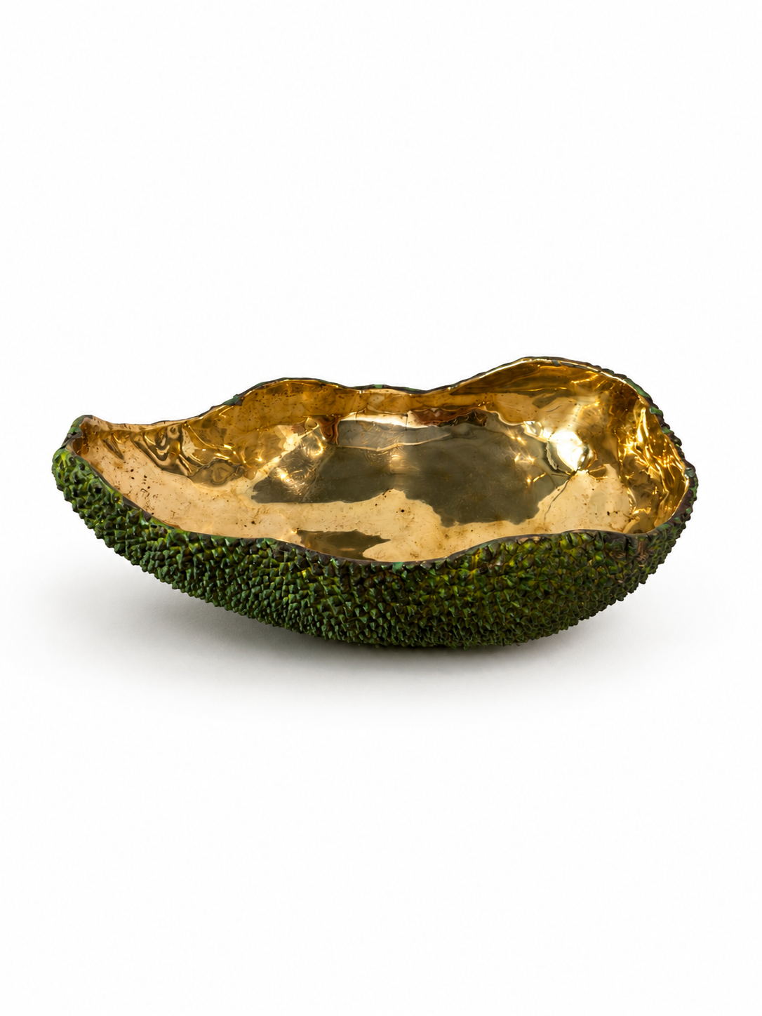 Decorative bowl made from a brass green fruit with gold interior on a white background