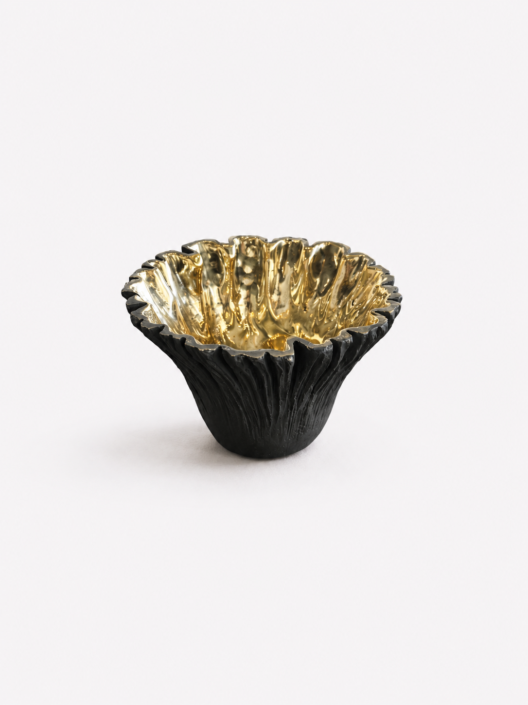 Black ruffled with gold interior brass bowl. Hight point view. 