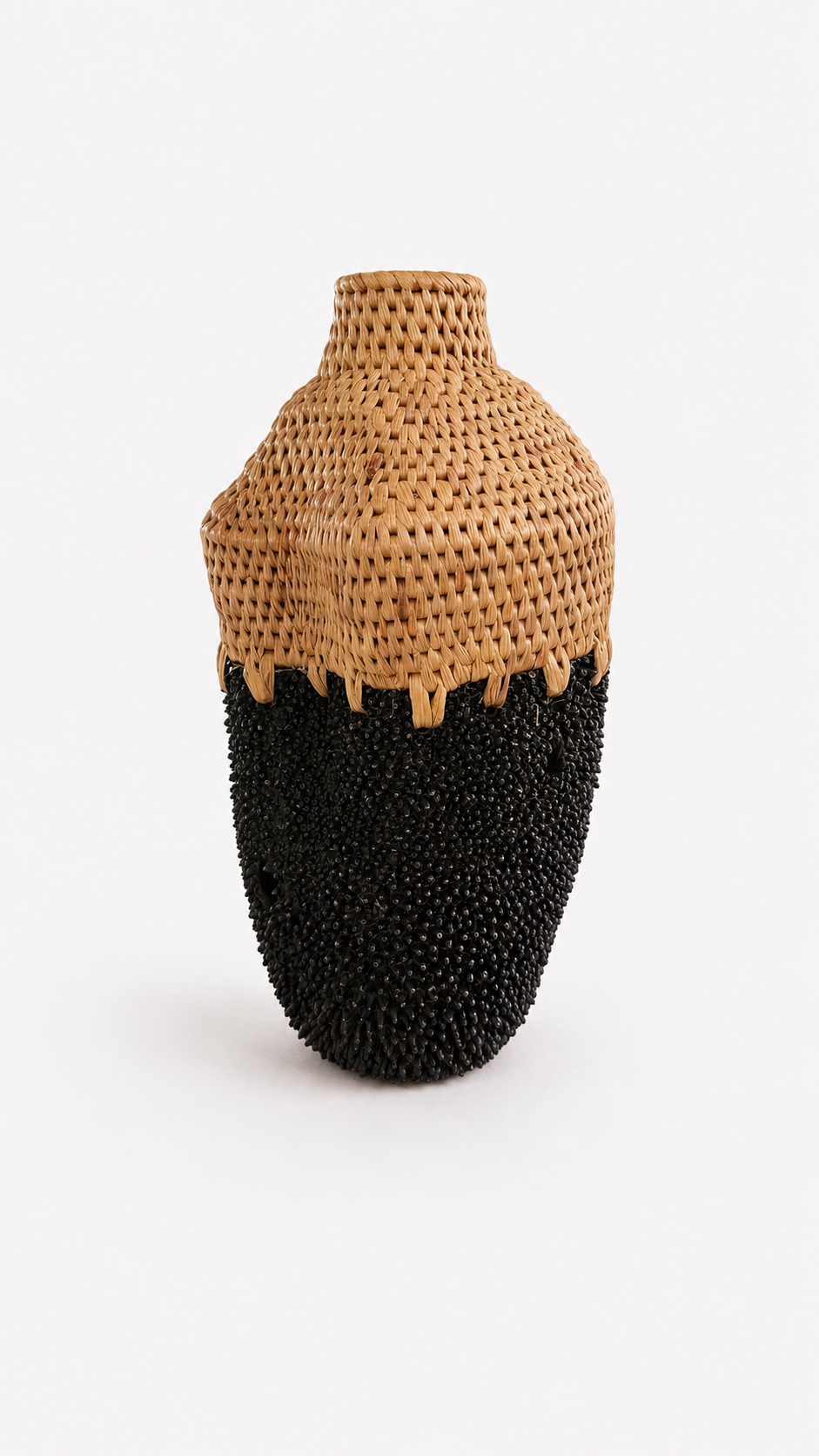Vase with woven top and black textured brass base on a white background