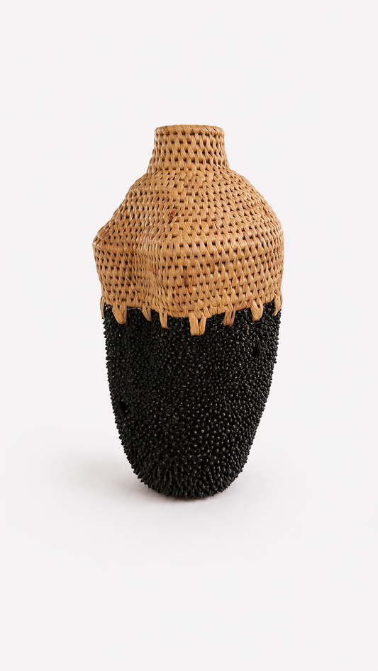 Vase with woven top and black textured brass base on a white background