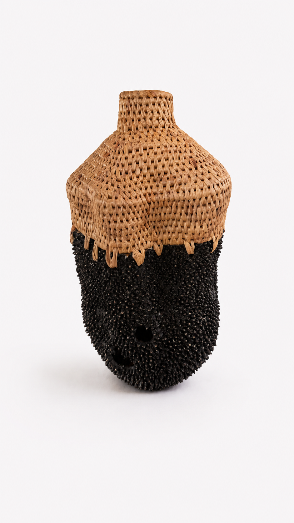 Vase with woven top and black textured brass base on a white background