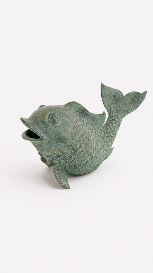 Green brass fish statue on a white background