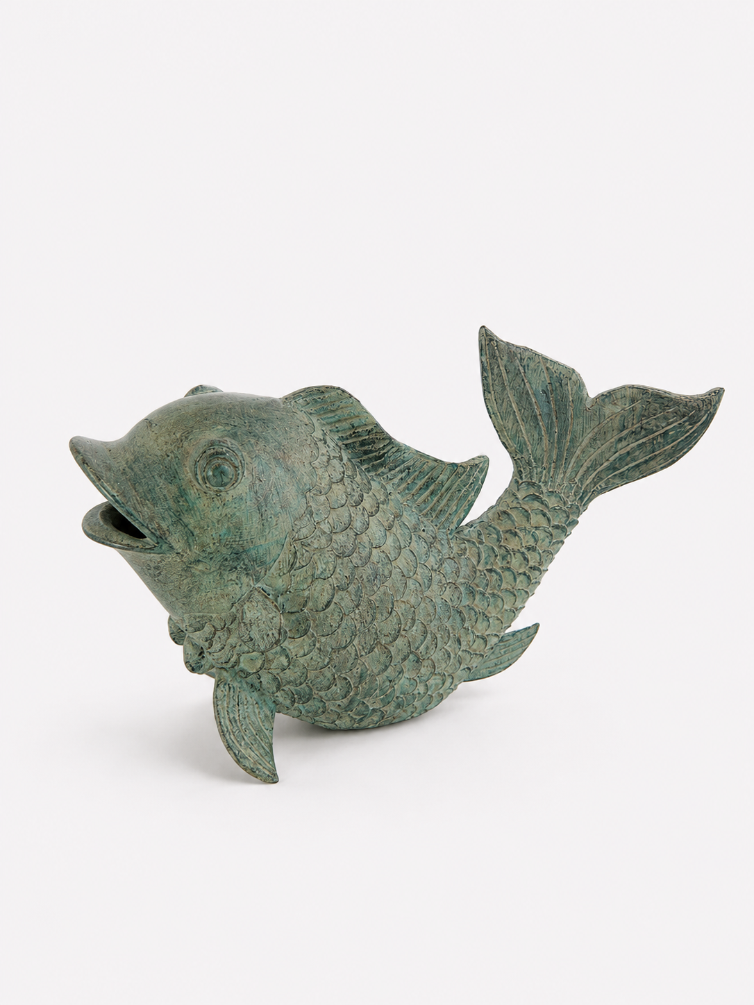 Green brass fish statue on a white background