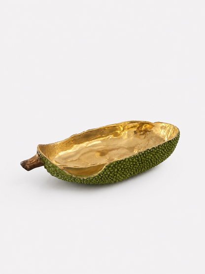 Decorative bowl made from a brass green fruit with gold interior on a white background