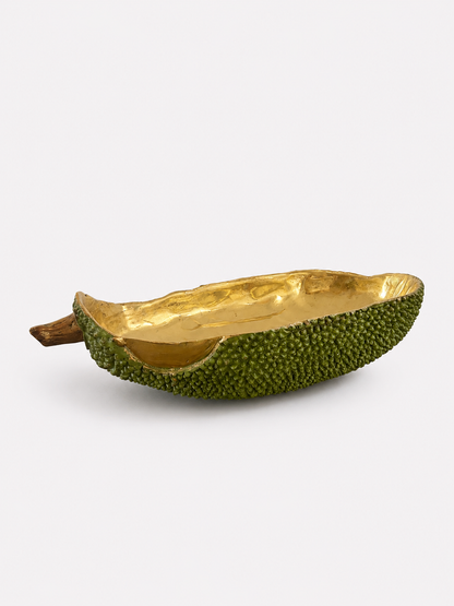 Decorative bowl made from a brass green fruit with gold interior on a white background
