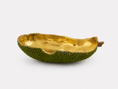 Decorative bowl made from a brass green fruit with gold interior on a white background