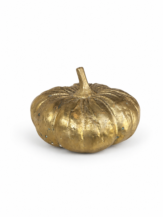 Gold brass pumpkin decoration on a white background
