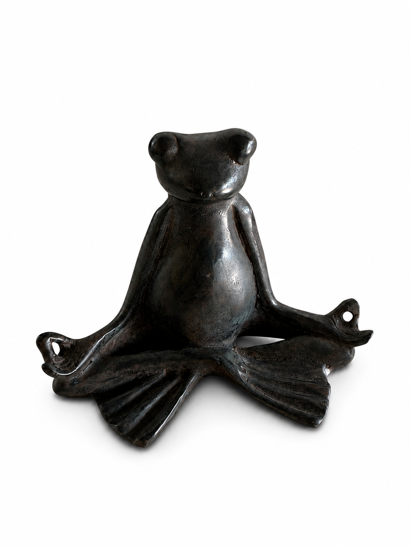 Brass frog sculpture in a meditative pose on a white background