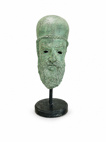 Green bronze mask on a stand and marble bottom against a white background